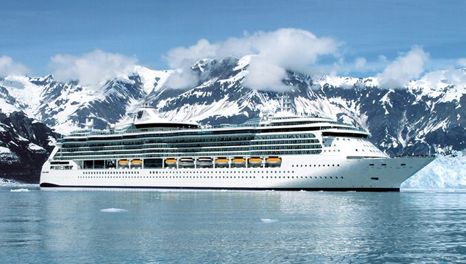 Cruise ship docked beneath mountains